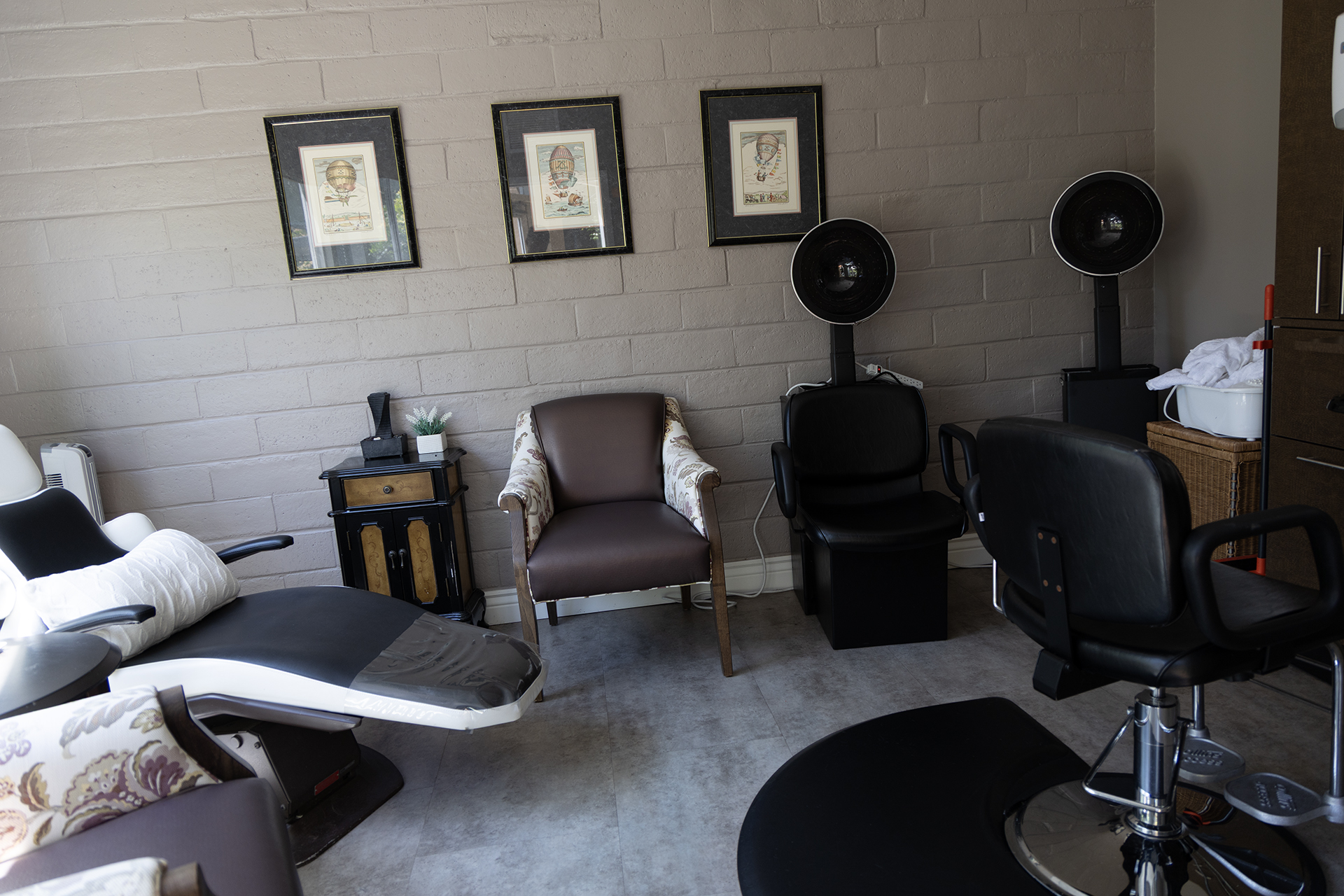 On-site salon with styling chairs, hair dryers, and hot air balloon prints on the wall