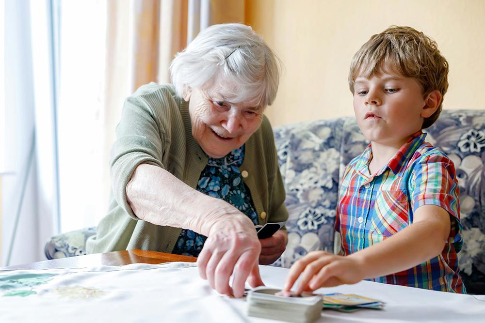 senior playing cards with child